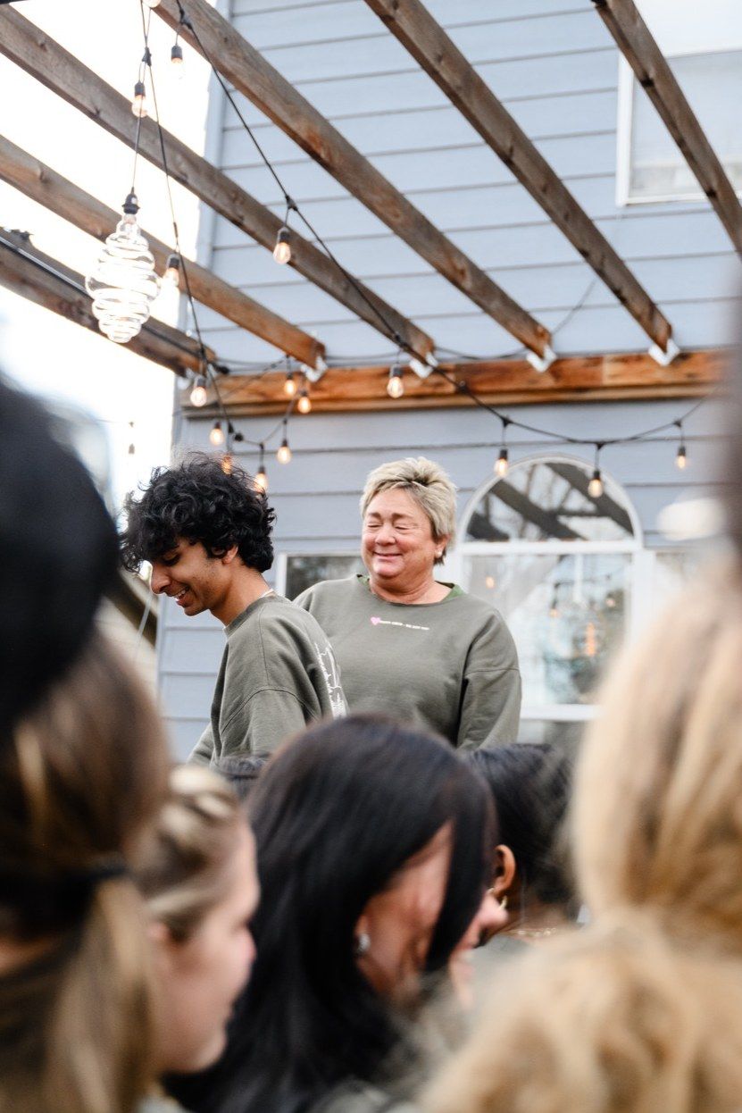 Amy laughing as she talks with a student on the deck under the pergola