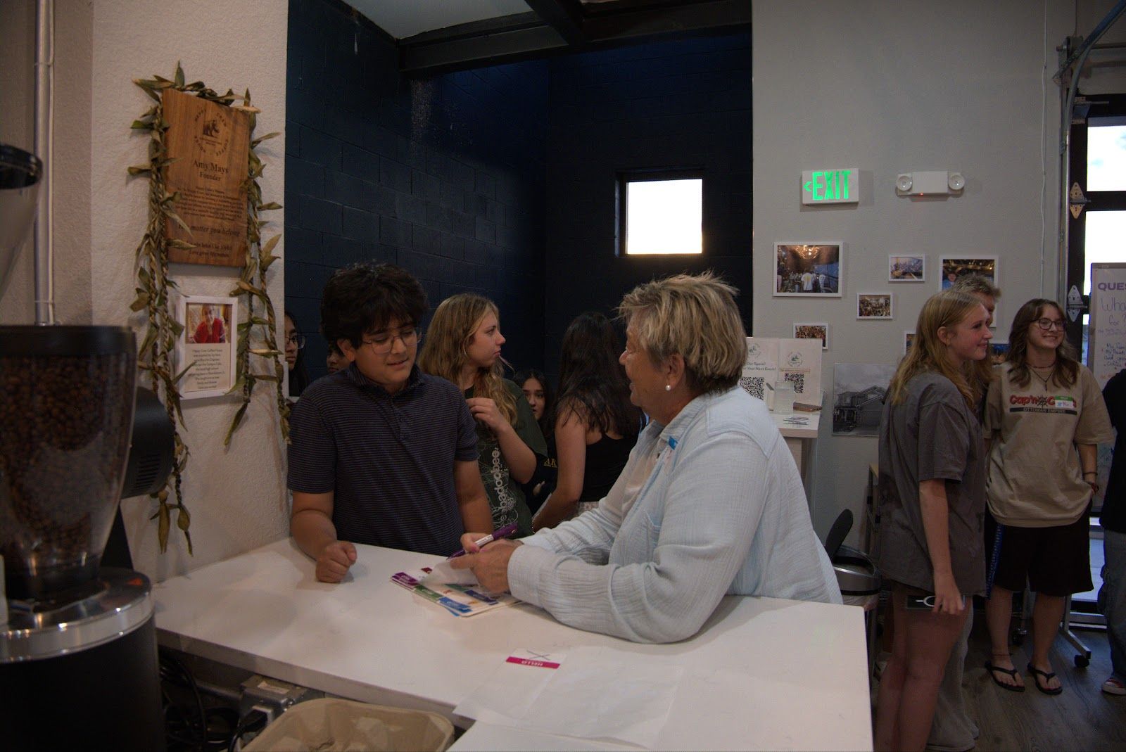 A teen writing a name tag at the welcome table